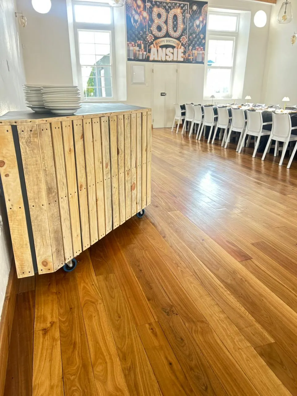 A movable timber bar counter in the foreground with laid tables beyond